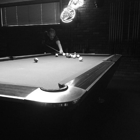 Picture of Ezra Buzzington playing pool in a pool club